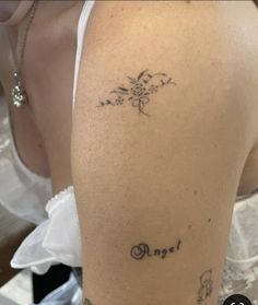 the back of a woman's shoulder with tattoos on it