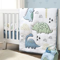 a baby crib bedding set with dinosaurs on it