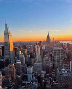 an aerial view of new york city at sunset with the empire building in the foreground