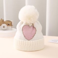 Product Introduction: Keep your little ones cozy and warm with our double-layered knitted hat featuring a darling love heart design. Made of durable acrylic material, this thick beanie is perfect for babies aging from 0-18 months. And with its sweet and charming look, it's sure to be an impulse buy for any parent looking for stylish and practical accessories. Heart Pompom, Girls Crochet Hats, Pompom Beanie, Baby Winter Hats, Wool Hat Knit, Toddler Accessories, Heart Red, Newborn Hat, Gold Lace