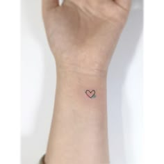 a small heart tattoo on the wrist