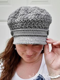 a woman wearing a gray crocheted hat