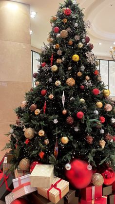 a large christmas tree with presents under it