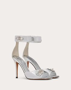 Valentino Garavani VLogo Locker sandal in mirrored calfskin - VLogo Signature swivel closure straps in tone-on-tone finish - Heel height: 105 mm / 4.2 in. - Made in Italy Luxury Sandals With 4-inch Heel And Single Toe Strap, Luxury Silver Heels With Buckle Closure, Luxury Patent Leather Sandals With Ankle Strap, Luxury Patent Leather Heels With Buckle Closure, Luxury Open Heel Heels With Buckle Closure, Luxury Patent Leather Sandals For Gala, Luxury Heels With Ankle Strap, Luxury Heels With Ankle Strap And Heel Strap, Luxury Heels With Heel And Ankle Strap