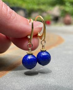 Lapis Lazuli Earrings. Gold Leverback Earrings. The Lapis Lazuli earrings are handmade using lapis lazuli, gold-filled and vermeil components. The round lapis beads are 10 mm wide; they have a deep blue color with specks and channels of pyrite/matrix, and they are accented by vermeil Bali daisies. Vermeil Euro-style or simple leverback earring wires bring the earrings to a total length of ~1 5/16 inches (3.3 cm). Lapis lazuli is a December birthstone. Pictures are enlarged to show detail. You will receive a remake of these lovely lapis lazuli gold leverback earrings. The earrings with Euro-style leverback earring wires weigh 5.1g (0.18oz) for the pair. The earrings ship in a small organza bag inside a gift box, ready to give... or keep! Additional WireAndPearl gold earrings can be found he Blue Round Bead Hoop Earrings Gift, Blue Hoop Earrings With Round Beads As Gift, Jewelry With Matching Round Bead Earrings For Gifts, Pierced Drop Earrings For Birthday, Handmade Lapis Lazuli Jewelry For Everyday, Adjustable Lapis Lazuli Earrings As Gift, Adjustable Lapis Lazuli Earrings For Gift, Jewelry With Matching Round Beaded Earrings For Gifts, Jewelry Set With Matching Round Bead Earrings For Gifts