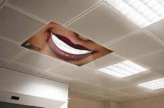 an image of a woman's mouth painted on the ceiling above a room with white walls