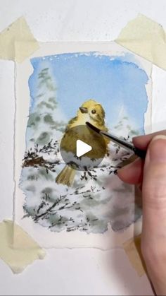 someone is painting a bird on the paper