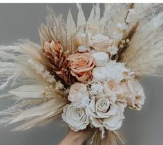 a hand holding a bouquet of flowers and feathers