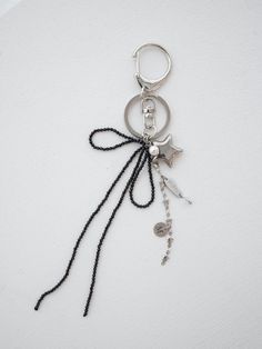 a keychain with beads and charms hanging from it's side on a white surface