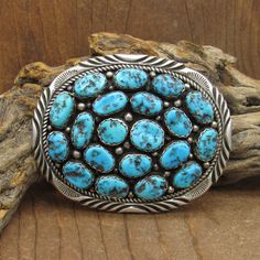 Southwestern sterling silver and turquoise belt buckle. The oval is 3" wide x 2 3/8" tall. There are 20 turquoise nuggets that are bezel set on the buckle. Several are 11mm long. There are silver balls and twisted silver wire rope adding to the design. The outside edge is stamped and has a pretty design cut into silver. The back is stamped W Sterling. This buckle will work with a 1 1/2" or more narrow belt. It is in good condition. Thank you for looking. Please let us know if you have questions. Western Style Oval Turquoise Ring With Concho, Western Oval Turquoise Ring With Concho, Oval Western Turquoise Ring With Concho, Western Style Oval Turquoise Concho Ring, Round Turquoise Buckle, Vintage Turquoise Belt With Concho, Southwestern Turquoise Concho Belt Buckles, Turquoise Belt Buckle, Luxury Silver Southwestern Belt Buckles