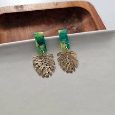 Add a touch of resort wear glam to your jewelry collection with our Mini Belize Earrings. These dainty earrings feature a delicate gold monstera leaf design, accented with vibrant acrylic details. Perfect for adding a pop of playfulness to any outfit.Hypoallergenic stainless steel posts20mm stud lengthLightweight and durable plant-based acetate acrylic postsGold-plated brass monstera leaf charms MSRP $23 Sustainable Swimwear, Hair Skin Nails, Leaf Charms, Monstera Leaf, Accessories Jewelry Earrings, Dainty Earrings, Accessories Earrings, Graphic Tee Shirts, Store Decor