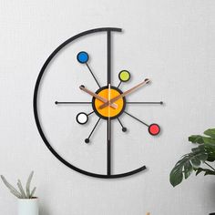 a clock that is on the side of a wall next to a potted plant