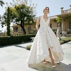 a woman in a wedding dress standing outside