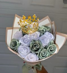 a bouquet of rolled flowers with a crown on top