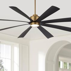 a ceiling fan with four black blades hanging from it's center point in an empty room