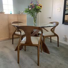 a glass table with wooden chairs around it