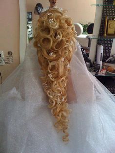 the back of a bride's wedding dress with curly hair