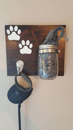 a mason jar is hanging on the wall next to a hook with a dog's paw print