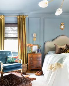 a bedroom with blue walls and gold curtains