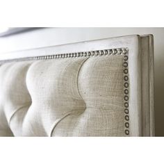 an upholstered headboard with beading and buttons on the bottom part of it