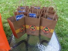 several brown paper bags sitting on top of a glass table covered in water and grass