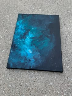 a painting is laying on the ground with blue and green stars in the night sky