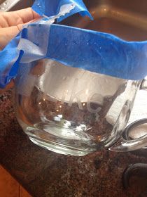 a person holding a blue ribbon over a glass bowl