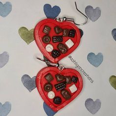 two red heart shaped key chains with chocolates in the shape of hearts on them