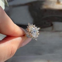 a person is holding an engagement ring in their left hand, with the diamond on it's side