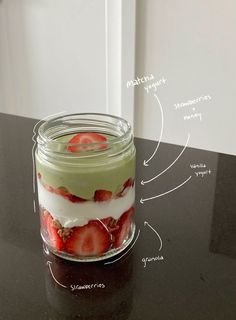 a mason jar filled with yogurt and strawberries on top of a table