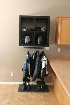 a coat rack with shoes and jackets hanging from it's hooks in a kitchen