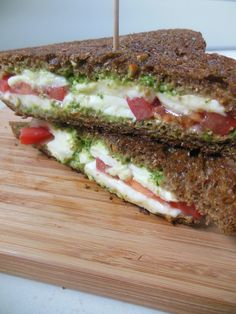 two sandwiches are sitting on a cutting board