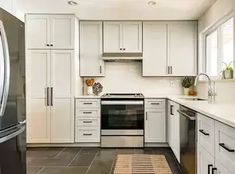 a kitchen with white cabinets and stainless steel appliances