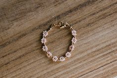 "This gold and pink flower beaded baby bracelet is so perfect for a baby shower gift or first birthday. Made with quality gold filled beads and materials that last with the right care. We highly recommend measuring your wrist for the best fit. Take a measuring tape and measure wrist tightly around (in inches). Add 1/2 inch and that's the size you should order.  Newborn: 3.5\" 0-6 months: 4\" 6-12 months: 4.5\" 1-3 years: 5\" 3-6 years: 5.5\" 6-12 years: 6\" Ladies XS, 6.5\" Ladies S, 7\" Ladies M, 7.5\" Ladies L, 8\" Ladies XL, 8.5\" Anklet XS, 8 Anklet S, 8.5 Anklet M, 9 Anklet L, 9.5" Cute Handmade Gold Beaded Bracelets, Cute Gold Beaded Bracelets For Birthday, Gold Flower Jewelry With Gold Beads, Gold Floral Jewelry With Gold Beads, Gold Flower-shaped Jewelry With Gold Beads, Gold Flower Jewelry With Tiny Beads, Gold Floral Jewelry With Tiny Beads, Gold Flower-shaped Jewelry With Tiny Beads, Dainty Pink 14k Gold-filled Bracelets