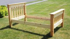 a wooden bed frame sitting in the grass