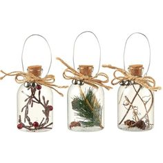 three glass bottles with christmas decorations in them