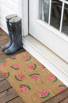 a door mat with watermelon on it next to a pair of rubber boots