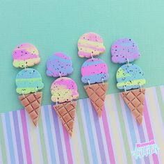 five ice cream treats are sitting on a striped tablecloth