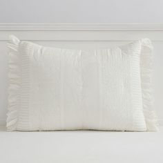 a white pillow sitting on top of a bed