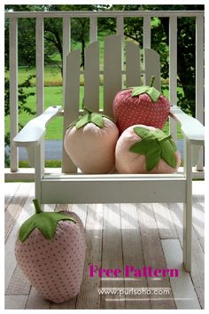 two stuffed strawberrys sitting on top of a white chair next to a pink strawberry