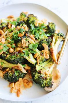 broccoli with cashews and peanuts on a white plate