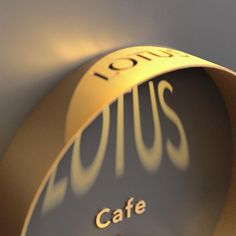 a close up of a clock with the words lotus cafe on it's face