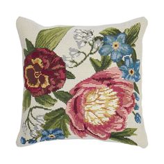 an embroidered pillow with flowers on the front and back, in red, white, blue and green colors