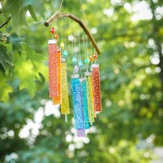 a wind chime hanging from a tree branch with beads and glass beads on it