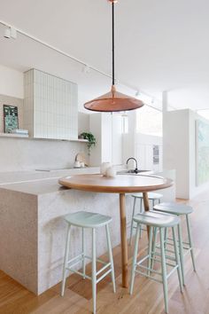 a kitchen with an island and stools next to the counter top in front of it