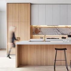 a kitchen with two stools next to an island and counter top that has marble on it