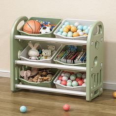 a green toy shelf filled with lots of toys and other items on top of a hard wood floor