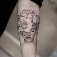 a woman's face with flowers in her hair on the left forearm and right arm