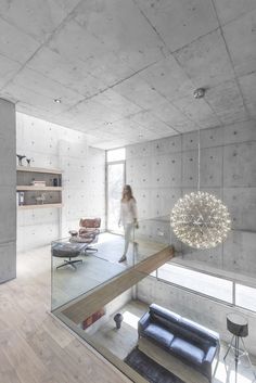 a woman is walking through a room with concrete walls