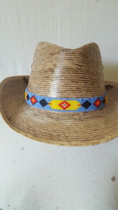 Discover the alluring beauty of our beaded Native American style hatband. Made with high-quality leather and beautifully detailed glass beads, these hatbands embody the rich and vibrant tradition of Native American design. Perfect for adding a unique and cultural flair to any hat style. Step out in a hatband that tells a story, represents art, and turns heads! Made by Mayan women in the hills of Guatemala. 13 rows of beads - 7/8 of an inch wide Beaded section 21.5 inches long Leather strands 6 inches on each side NOS-New condition **HAT NOT INCLUDED** Southwestern Style Beaded Festival Hats, Beaded Hatbands Native American, Traditional Hat Bands For Festivals, One Size Fits Most, Western Beaded Hat Bands For Western-themed Events, Artisan Beaded Hat Bands For Western-themed Events, Navajo Style, Beaded Hat, Native American Design, Native American Fashion